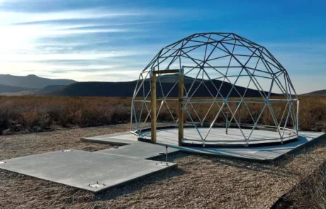 Geodesic dome frame on a concrete pad for glamping expansion at Glamp the World in Clint, TX
