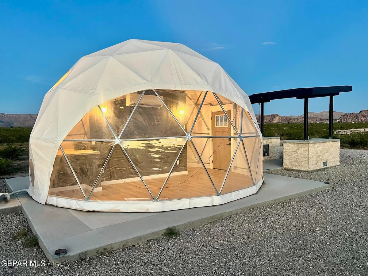 Luxury glamping dome lit up at dusk with covered patio, Glamp the World in Clint, TX
