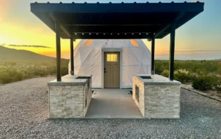 Glamping dome with covered outdoor kitchen and stone counters at Glamp the World in Clint, TX