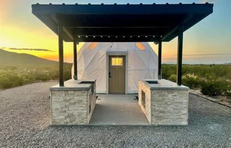 Glamping dome with covered outdoor kitchen and stone counters at Glamp the World in Clint, TX