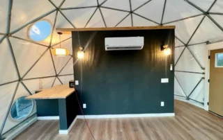 Glamping dome interior with dark accent wall and mini split AC at Glamp the World, Clint, TX