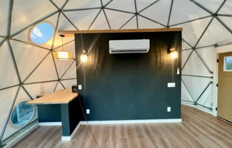 Glamping dome interior with dark accent wall and mini split AC at Glamp the World, Clint, TX